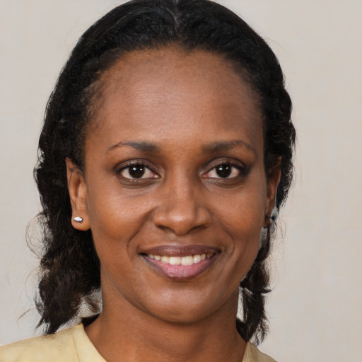 Joyful black young-adult female with medium  brown hair and brown eyes