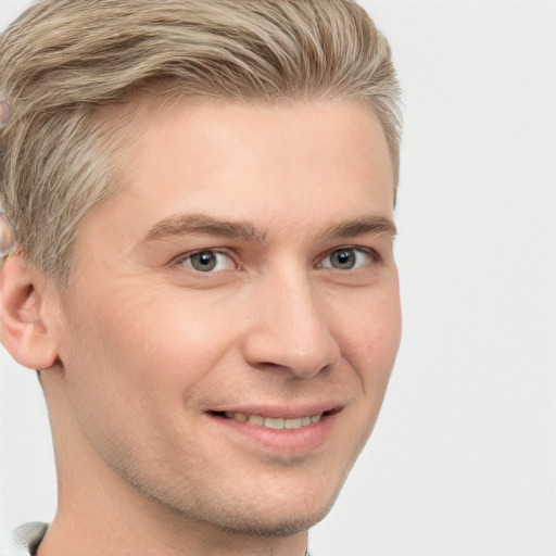 Joyful white young-adult male with short  brown hair and grey eyes