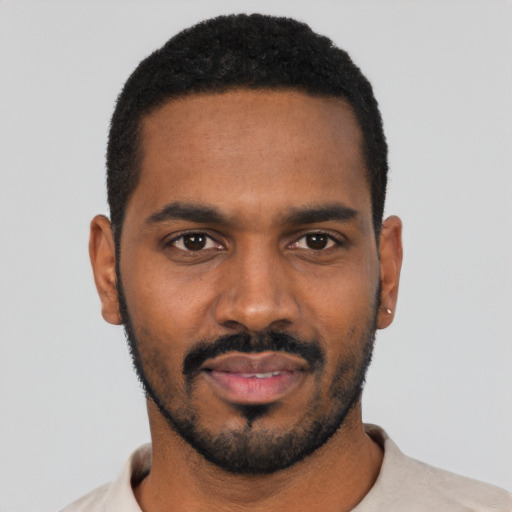 Joyful black young-adult male with short  black hair and brown eyes