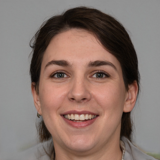 Joyful white young-adult female with medium  brown hair and grey eyes