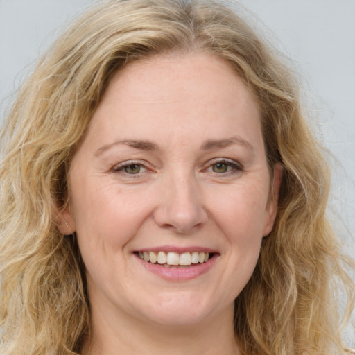 Joyful white adult female with long  brown hair and green eyes