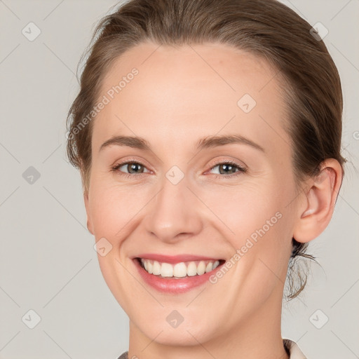 Joyful white young-adult female with medium  brown hair and grey eyes