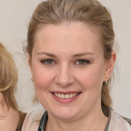 Joyful white young-adult female with medium  brown hair and blue eyes