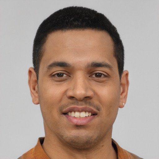 Joyful latino young-adult male with short  black hair and brown eyes