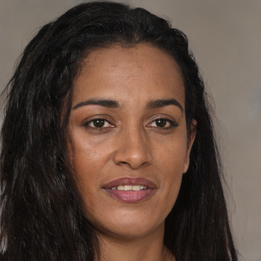 Joyful black young-adult female with long  brown hair and brown eyes