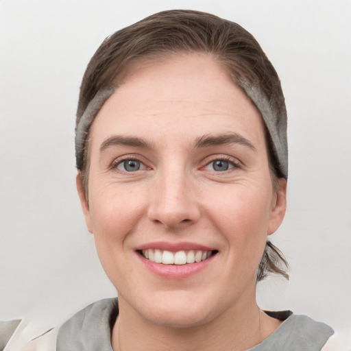 Joyful white young-adult female with short  brown hair and grey eyes