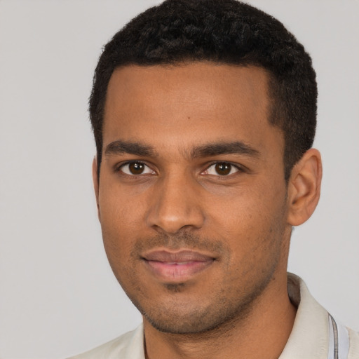 Joyful black young-adult male with short  brown hair and brown eyes