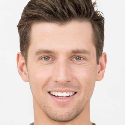 Joyful white young-adult male with short  brown hair and grey eyes