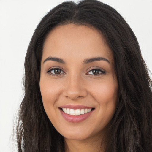 Joyful latino young-adult female with long  brown hair and brown eyes