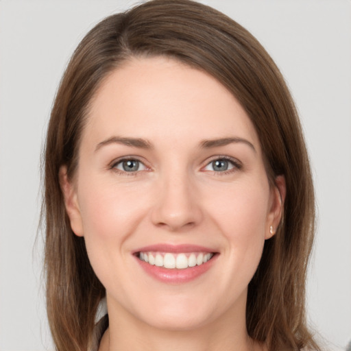 Joyful white young-adult female with long  brown hair and grey eyes