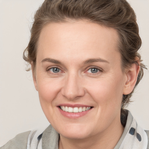 Joyful white young-adult female with medium  brown hair and grey eyes