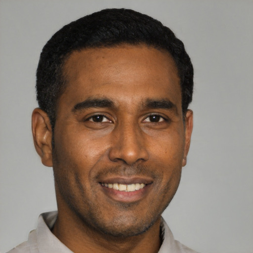 Joyful black young-adult male with short  black hair and brown eyes