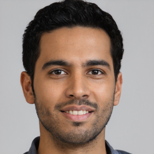 Joyful latino young-adult male with short  black hair and brown eyes