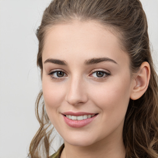 Joyful white young-adult female with long  brown hair and grey eyes