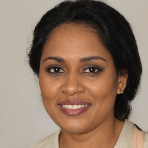 Joyful black young-adult female with medium  brown hair and brown eyes
