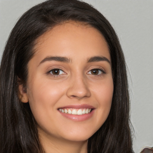 Joyful white young-adult female with long  brown hair and brown eyes