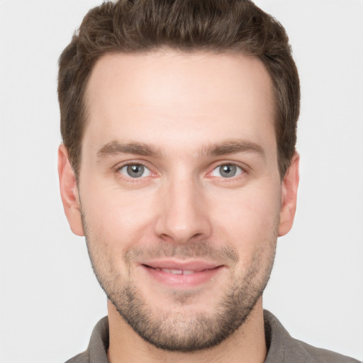 Joyful white young-adult male with short  brown hair and grey eyes