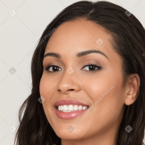 Joyful latino young-adult female with long  brown hair and brown eyes