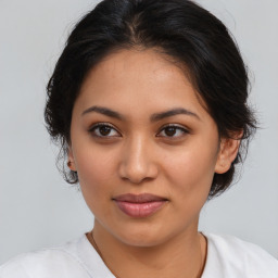 Joyful latino young-adult female with medium  brown hair and brown eyes