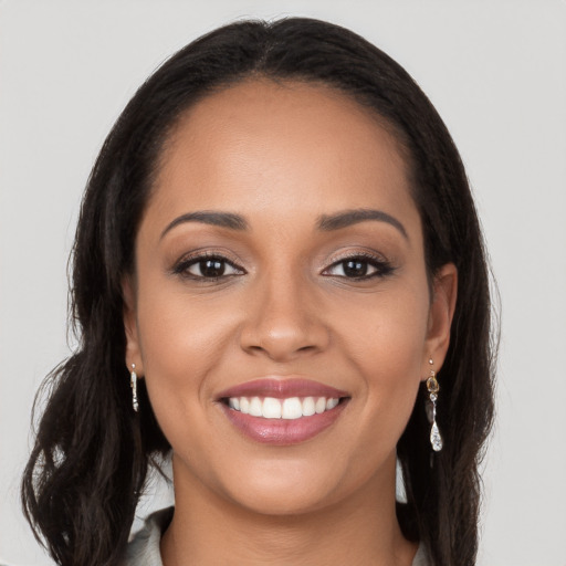 Joyful latino young-adult female with long  brown hair and brown eyes