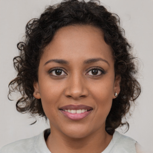 Joyful black young-adult female with medium  brown hair and brown eyes