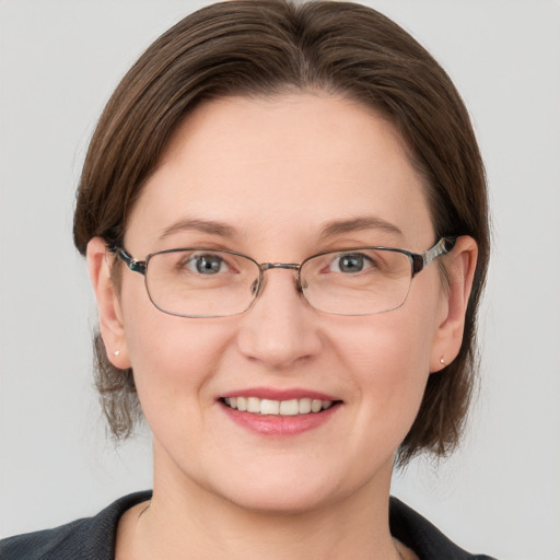 Joyful white adult female with medium  brown hair and grey eyes