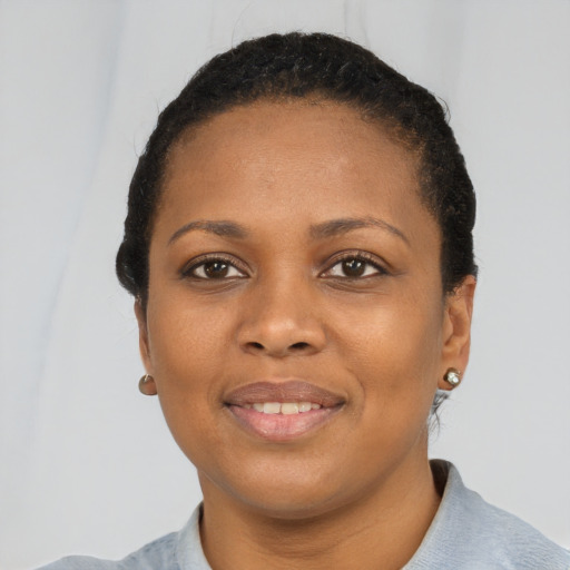 Joyful black young-adult female with short  black hair and brown eyes