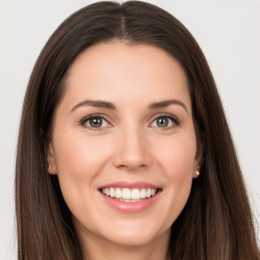 Joyful white young-adult female with long  brown hair and brown eyes