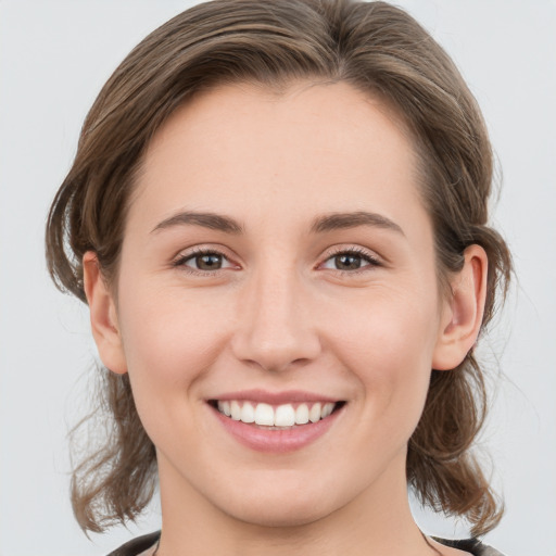 Joyful white young-adult female with medium  brown hair and grey eyes