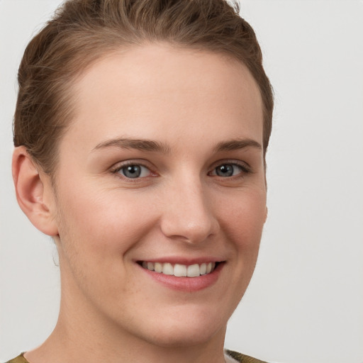 Joyful white young-adult female with short  brown hair and grey eyes