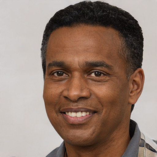 Joyful black adult male with short  black hair and brown eyes
