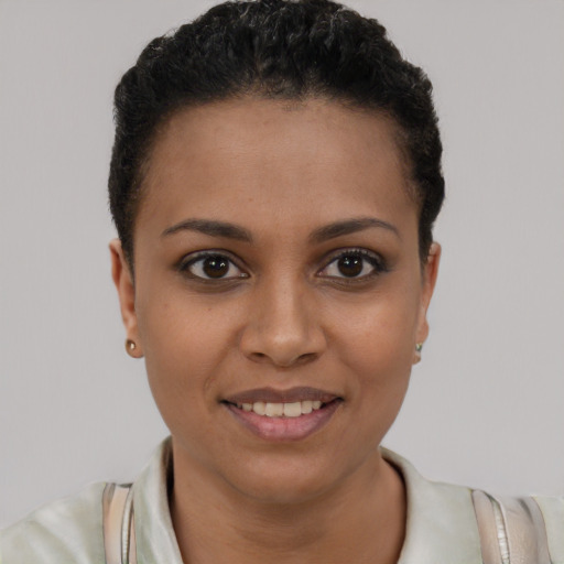 Joyful black young-adult female with short  brown hair and brown eyes