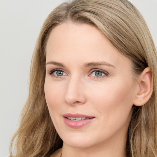 Joyful white young-adult female with long  brown hair and blue eyes