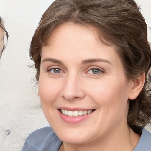 Joyful white young-adult female with medium  brown hair and blue eyes