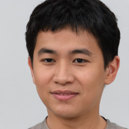 Joyful asian young-adult male with short  brown hair and brown eyes