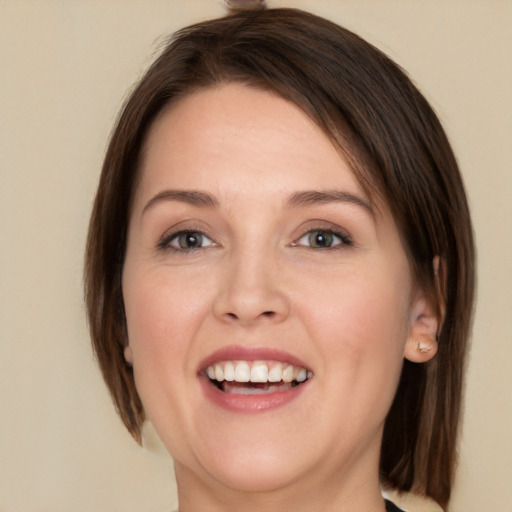 Joyful white young-adult female with medium  brown hair and green eyes