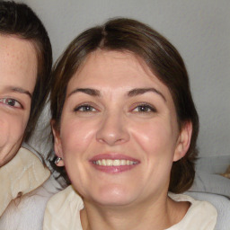 Joyful white adult female with medium  brown hair and blue eyes