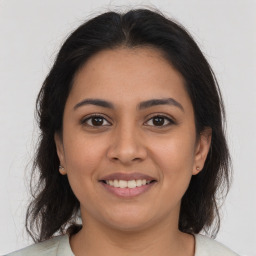 Joyful latino young-adult female with medium  brown hair and brown eyes