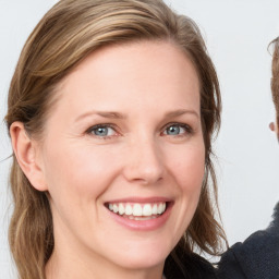 Joyful white young-adult female with medium  brown hair and blue eyes