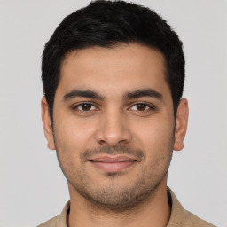 Joyful latino young-adult male with short  black hair and brown eyes