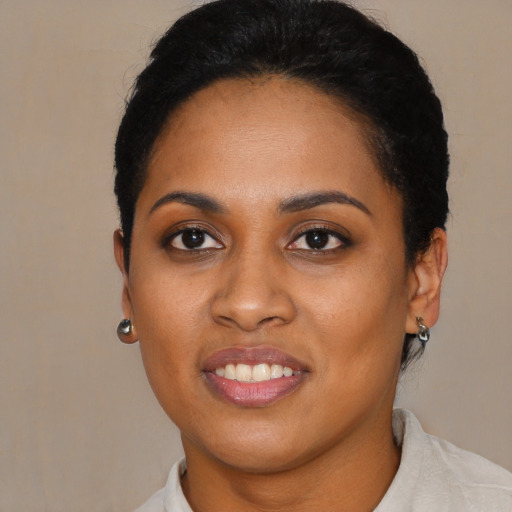 Joyful black young-adult female with short  black hair and brown eyes