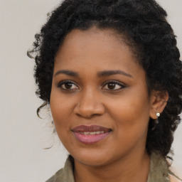 Joyful black young-adult female with long  brown hair and brown eyes