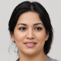 Joyful latino young-adult female with medium  brown hair and brown eyes