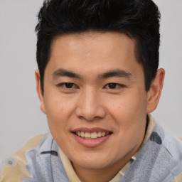 Joyful asian young-adult male with short  brown hair and brown eyes