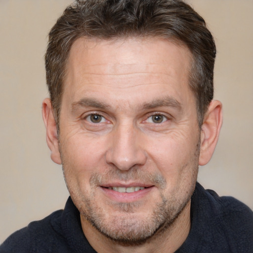 Joyful white adult male with short  brown hair and brown eyes