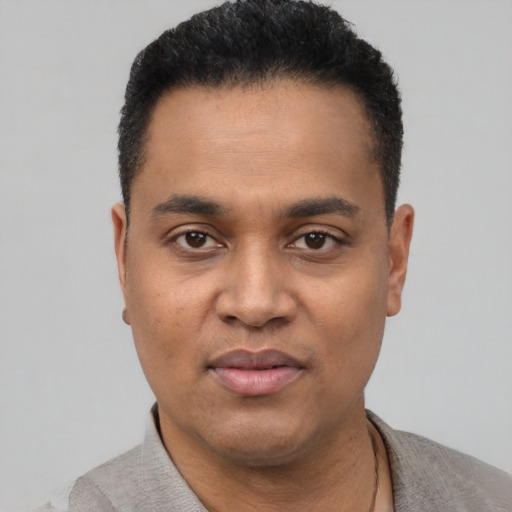 Joyful black young-adult male with short  black hair and brown eyes