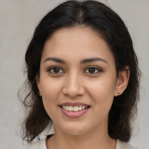 Joyful latino young-adult female with medium  brown hair and brown eyes