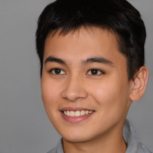 Joyful asian young-adult male with short  brown hair and brown eyes