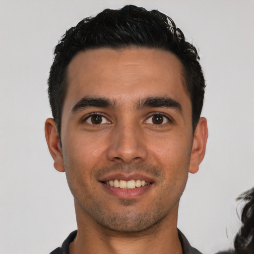 Joyful white young-adult male with short  black hair and brown eyes