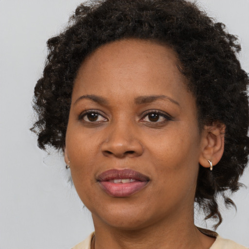 Joyful black adult female with medium  brown hair and brown eyes